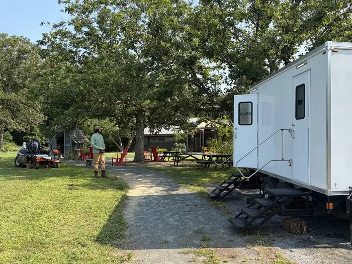 Restroom trailer with separate men and women entrances at an outdoor Eastern Shore venue