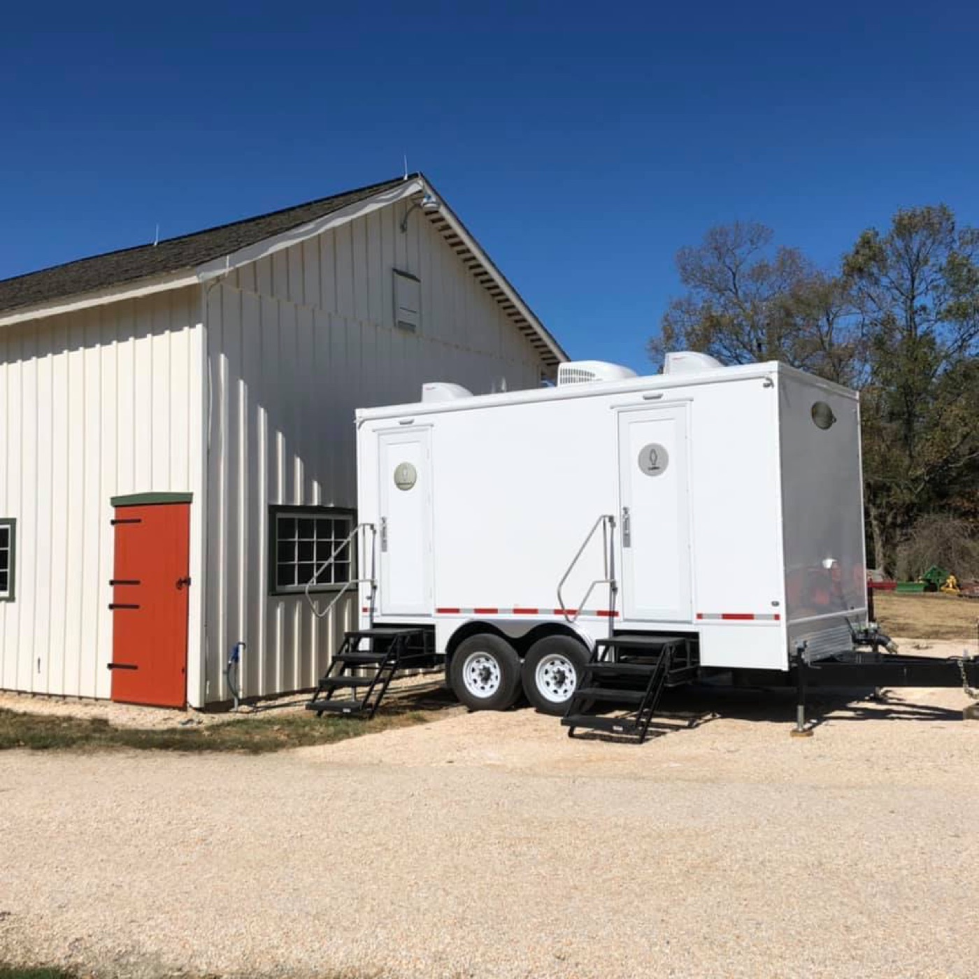 Restroom trailer delivered and levelled beside a barn venue